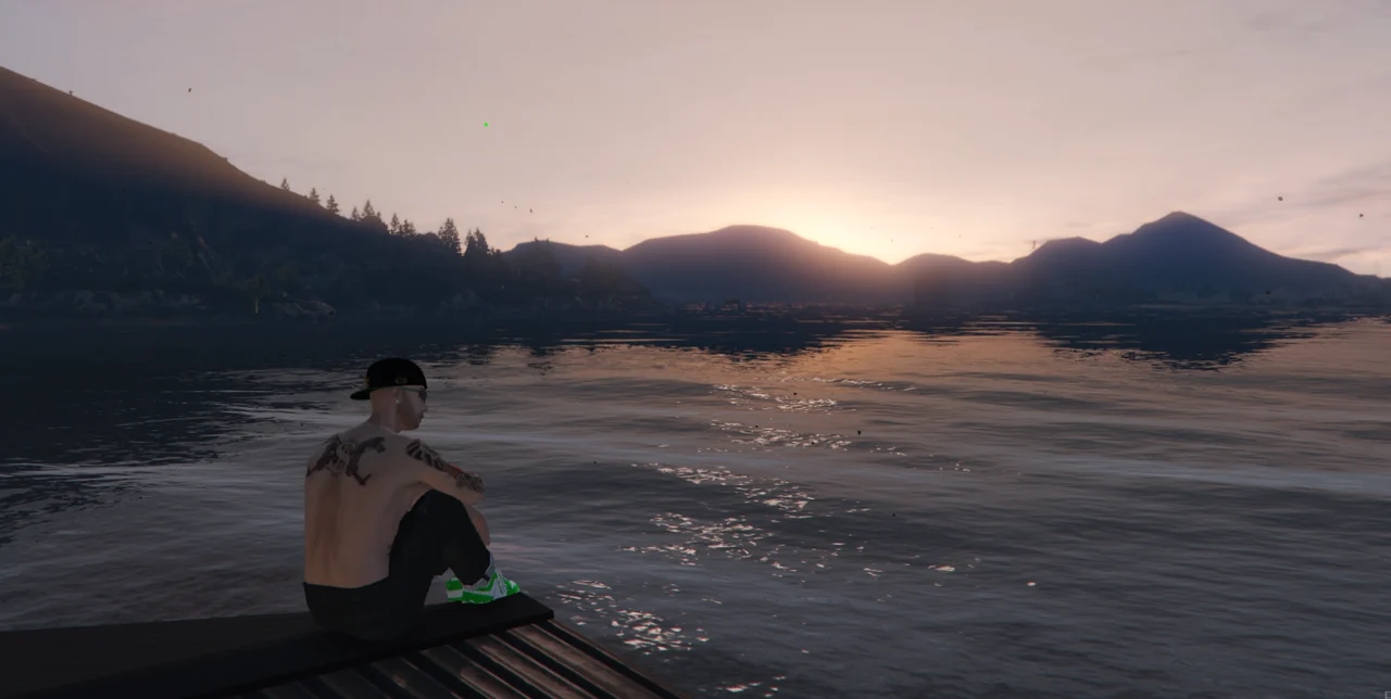 A player sitting on a dock at sunset